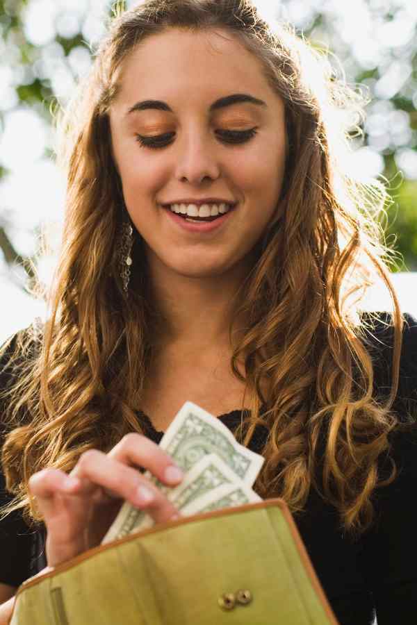 teen girl pulling money out of a wallet